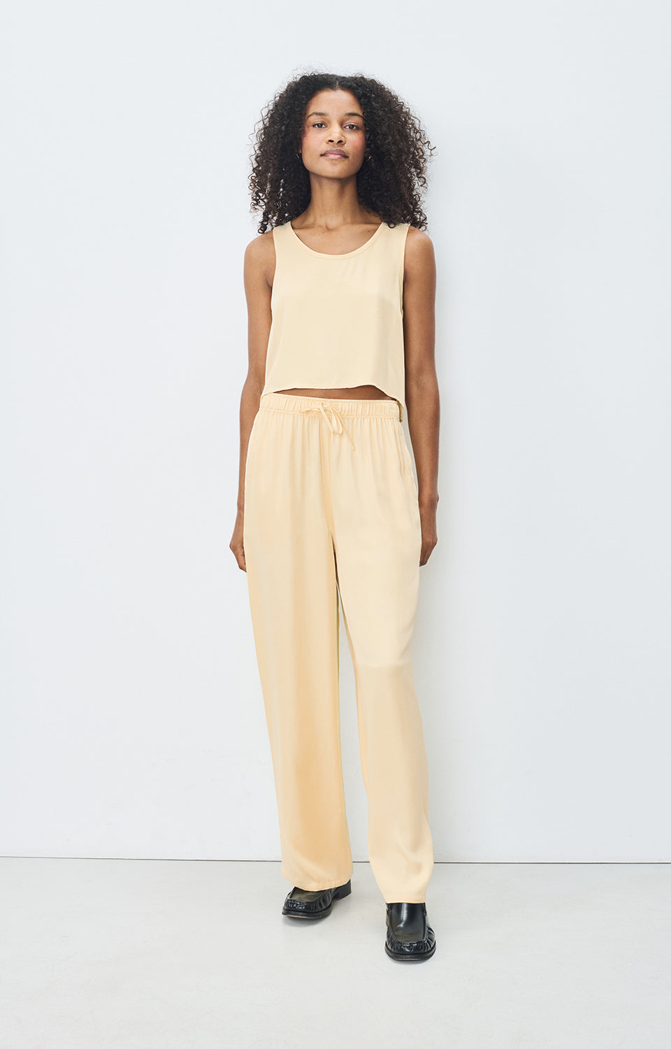 Front view of American Vintage G-UNY10B wide-leg pants in Butter satin viscose with elastic drawstring waistband, available at MEZI Australia.