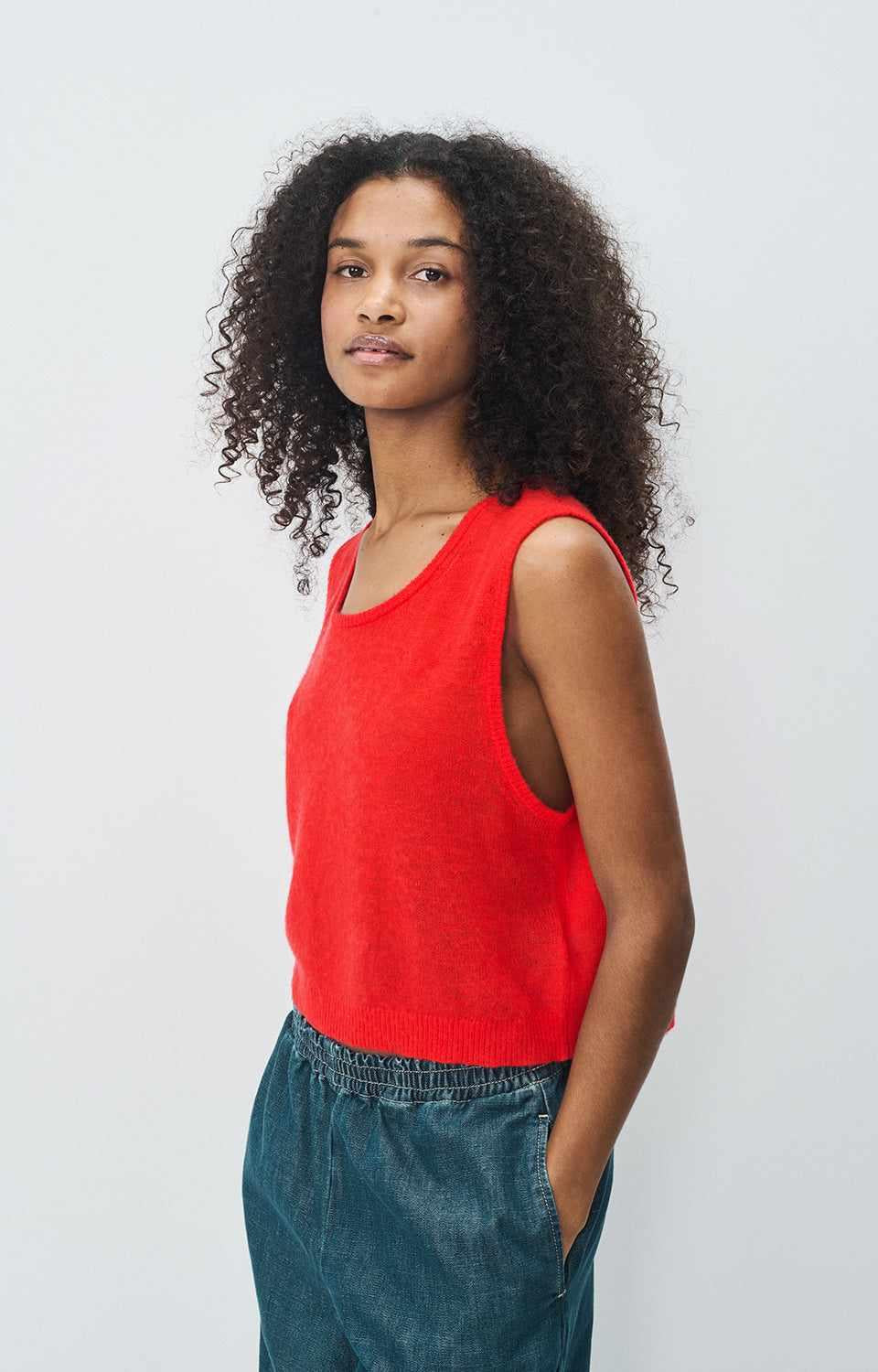 Model wearing American Vintage wool-cashmere tank sweater G-DUM18B in red, side profile and relaxed fit, at MEZI Australia.